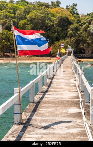Lange Anlegestelle ins Meer mit thailändischer Flagge am Wat Koh Phayam Tempel, Koh Phayam. Thailand Stockfoto