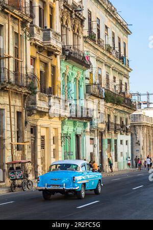 Oldtimer fahren durch die kubanische Straße mit alten, bunten Fassaden im Kolonialstil, Old Havana, Kuba Stockfoto