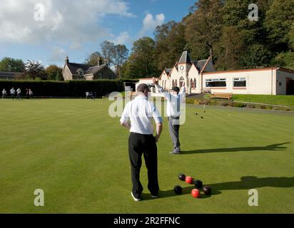 Ein Mann erhebt seine Arme im Sieg während Bowls im Spiel vor dem Pavillon des Stirling Rasen Bowling Club Green in Stirling, Schottland, Großbritannien Stockfoto