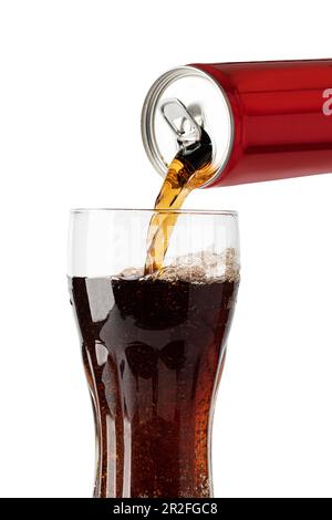 Cola-Soda-Getränk wird aus der Dose in Glas eingegossen, isoliert auf weißem Hintergrund Stockfoto