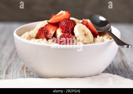 Zubereiteter Haferbrei mit Früchten und Beeren auf einem Holztisch Stockfoto