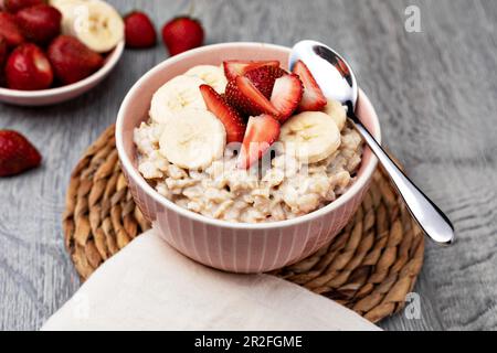 Zubereiteter Haferbrei mit Früchten und Beeren auf einem Holztisch Stockfoto