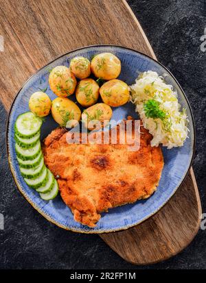 Schweinspanierte Kotelett mit Paniermehl überzogen, serviert mit Kartoffeln und Kohl Stockfoto