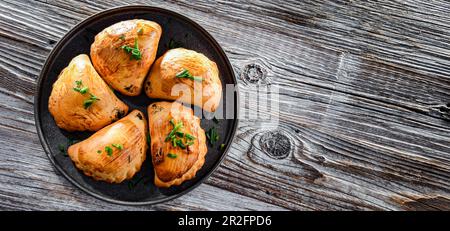 Zusammensetzung mit einem Teller aus im Ofen gebackenen Pierogi Stockfoto