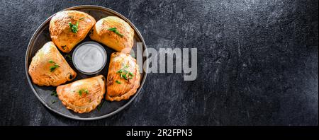 Zusammensetzung mit einem Teller aus im Ofen gebackenen Pierogi Stockfoto