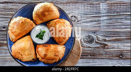 Zusammensetzung mit einem Teller aus im Ofen gebackenen Pierogi Stockfoto