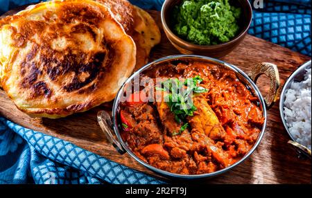 Butterhähnchen mit Reis und Naan-Fladenbrot, serviert in originalen indischen Karahi-Töpfen Stockfoto