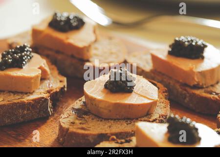 Selektiver Fokus auf schwarzem Kaviar mit Foie Gras und Brot schneiden, Fevtive Feier Konzept Stockfoto