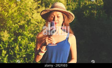 Glückliche asiatische Frau trinkt Rotwein, Feier Konzept Stockfoto