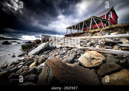 Langlebige Salz-Kabeljau-Trockenständer aus Holz und historisches Gebäude an einer felsigen Küste mit Blick auf den Atlantischen Ozean in Bonavista Neufundland Canada. Stockfoto