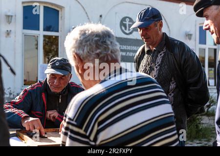 Einige ältere Männer spielen Backgammon in der Innenstadt, Sulina, Tulcea, Rumänien. Stockfoto