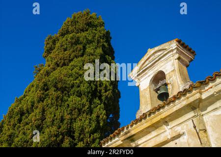 Kirche mit Glocke und einem Baum mit klarem blauen Himmel im Park San Michele in Castagnola in Lugano, Tessin in der Schweiz Stockfoto