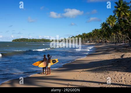 Junge Männer mit Surfbrettern am Strand, Praia da Cueira, Boipeba Island, Bahia, Brasilien, Südamerika Stockfoto
