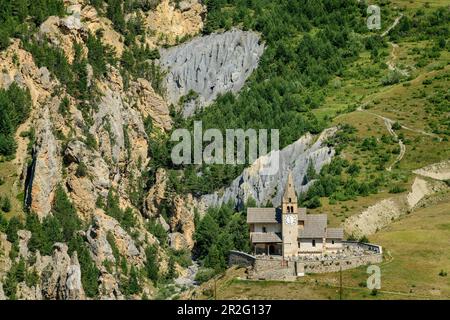 Kirche und Erosionslandschaft von Cervieres an Col d'Izoard, Col d'Izoard, Cottian Alps, Hautes-Alpes, Frankreich Stockfoto