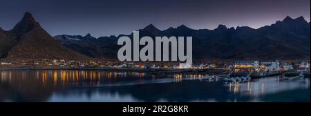 Abendlicher Panoramablick auf das beleuchtete Dorf Mefjordvaer, Senja, Norwegen mit dem Berg Litjedalsvatnet Stockfoto