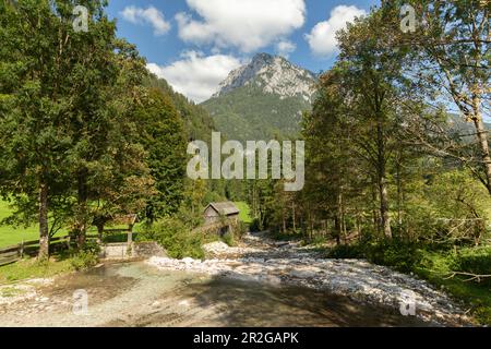 Alte Wassermühle am Fluss Bela. Mozirje, Solcava, Slowenien. Berge im Hintergrund Stockfoto