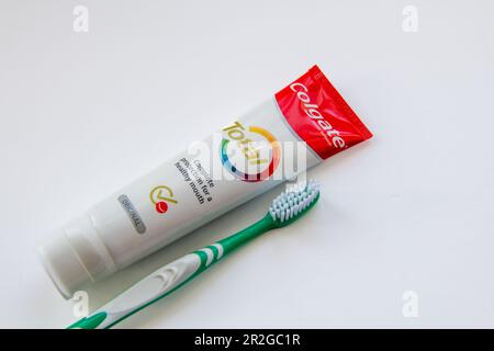 Nach London. GROSSBRITANNIEN - 05.16.2023. Nahaufnahme einer Tube Colgate-Zahnpasta mit einer weiß isolierten Zahnbürste. Stockfoto