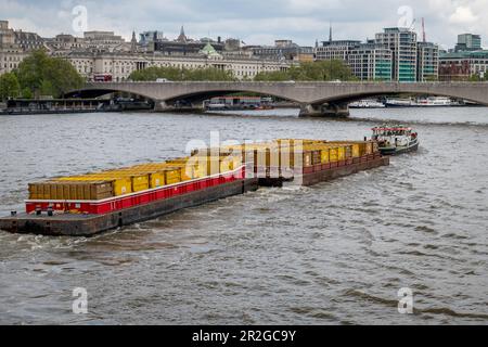 Nach London. GROSSBRITANNIEN - 05.17.2023. Ein Schleppboot, das Frachtkähne voller Container zieht. Transport von Gütern auf dem Wasser auf der Themse. Stockfoto