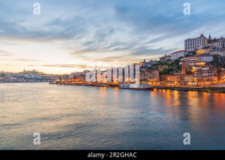 Nachtaufnahme der Uferpromenade Cais de Ribeira und der historischen Altstadt von Porto, Portugal Stockfoto