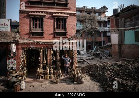 Frau im Souvenirladen neben dem Haus zerstört durch Erdbeben, Bhaktapur, Lalitpur, Kathmandu-Tal, Nepal, Himalaya, Asien, UNESCO-Weltkulturerbe Stockfoto