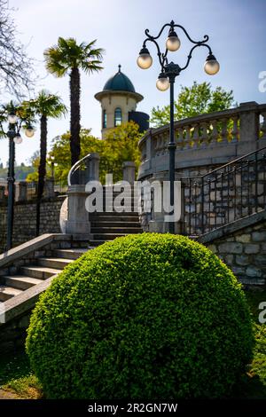 Wunderschöner Park mit Treppe und Palmen und Sonnenlicht in Lugano an einem sonnigen Tag in Tessin, Schweiz. Stockfoto