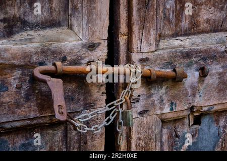 Alte Straßen, Wege und Durchbrüche im Zentrum von Gandria. Skurrile Eingangstüren und Straßenlaternen. Stockfoto