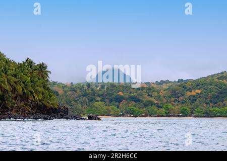 Nordküste mit Fischerdorf Praia das Burras und Strand und Blick auf Pico Papagaio auf der Insel Príncipe in Westafrika Stockfoto