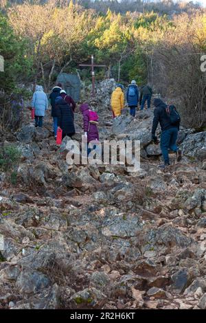 Eine Gruppe junger Leute, die an einem kalten Februar-Morgen in Medjugorje auf den Berg Križevac klettern. Stockfoto
