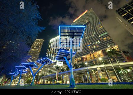 Moderne städtische Neonbeleuchtung mit Solarpaneelen für die Stromversorgung von Straßenleuchten und Überwachungskameras. Futuristische Energie sauer Stockfoto