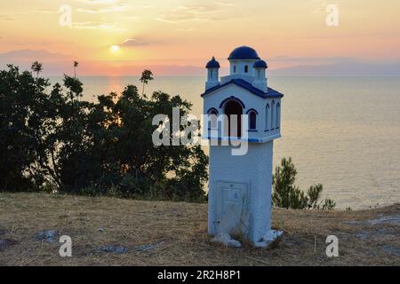 Traditionelle Miniaturkirche am Meer vor dem Hintergrund des Sonnenuntergangs, Sommeratmosphäre, Thassos Insel, Griechenland Stockfoto