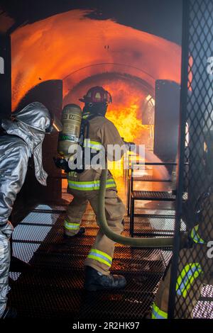 USA Feuerwehrleute der Luftwaffe, die dem 180. Kampfflug der Ohio National Guard zugeteilt sind, löschen ein Feuer während einer kontrollierten Brandübungsveranstaltung am Eugene F. Kranz Toledo Express Airport in Swanton, Ohio, 9. Mai 2023. Die Übung bot ein realistisches Schulungsszenario, das sicherstellte, dass die Feuerwehrleute umfassend geschult, qualifiziert und für den Einsatz in der ganzen Welt vorbereitet sind. (USA Air National Guard Foto von Staff Sgt. Kregg York) Stockfoto