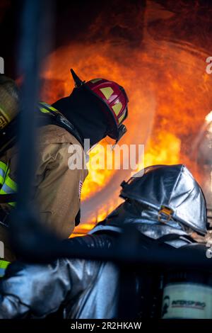 USA Feuerwehrleute der Luftwaffe, die dem 180. Kampfflug der Ohio National Guard zugeteilt sind, löschen ein Feuer während einer kontrollierten Brandübungsveranstaltung am Eugene F. Kranz Toledo Express Airport in Swanton, Ohio, 9. Mai 2023. Die Übung bot ein realistisches Schulungsszenario, das sicherstellte, dass die Feuerwehrleute umfassend geschult, qualifiziert und für den Einsatz in der ganzen Welt vorbereitet sind. (USA Air National Guard Foto von Staff Sgt. Kregg York) Stockfoto