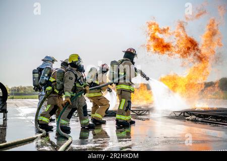 USA Feuerwehrleute der Luftwaffe, die dem 180. Kampfflug der Ohio National Guard zugeteilt sind, löschen ein Feuer während einer kontrollierten Brandübungsveranstaltung am Eugene F. Kranz Toledo Express Airport in Swanton, Ohio, 9. Mai 2023. Die Übung bot ein realistisches Schulungsszenario, das sicherstellte, dass die Feuerwehrleute umfassend geschult, qualifiziert und für den Einsatz in der ganzen Welt vorbereitet sind. (USA Air National Guard Foto von Staff Sgt. Kregg York) Stockfoto