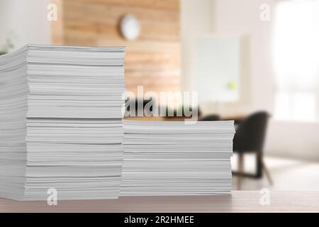 Gestapelte Papierbögen auf einem Holztisch im Büro, Platz für Text Stockfoto