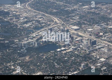 Orlando, Florida, ist ein geschäftiges Stadtbild, umgeben von üppigem Grün, das Themenparks, Seen, pulsierende Viertel und die berühmte Landmar aus der Vogelperspektive zeigt Stockfoto