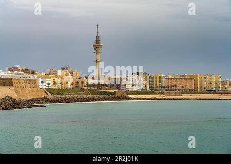 Die Küste mit dem Telekommunikationsturm La Torre Tavira II und dem Strand Playa de Santa María del Mar in Cadiz, Andalusien, Spanien Stockfoto