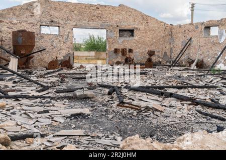 19. Mai 2023, Region Kherson, Ukraine: Die Vernichtung der Düngemittellageranlage der Farm Pershe Travnia des Dorfes Velyka Oleksandrivka der Region Kherson aus Sicht der Befreiung von der russischen Invasion. Der Betrieb erzeugte Getreide (Weizen, Gerste, Sonnenblumen), Fleisch (Schweinefleisch) und andere Erzeugnisse; Mit 100 Beschäftigten und mehr als 3.000 Hektar Ackerfläche, mehr als 1200 Schweinen. Der Betrieb wurde vollständig zerstört, die gesamte Ausrüstung, die Ernte von 2021, der Dünger, alle Gebäude einschließlich Getreidelager und Orte, an denen Schweine gehalten und gefüttert wurden. Nach dem Bombenanschlag wurden Schweine entweder lebendig verbrannt, einige kamen rein Stockfoto