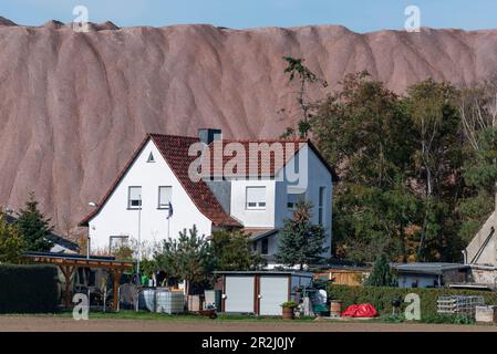 Einfamilienhaus, dahinter die Abraumhalde der Kalifabrik in Zielitz, K Stockfoto