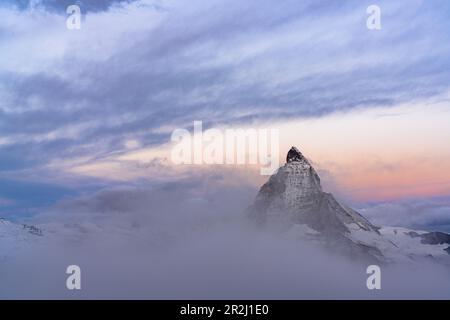 Wolken über dem Matterhorn-Gipfel, der bei Sonnenaufgang aus dem Nebel auftaucht, Gornergrat, Zermatt, Kanton Wallis, Schweiz, Europa Stockfoto