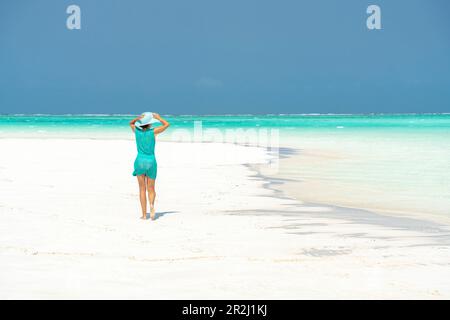 Eine Frau, die am idyllischen, leeren Strand spaziert, Sansibar, Tansania, Ostafrika, Afrika Stockfoto