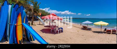 Blick auf farbenfrohe Sonnenschirme und Surfbretter am sonnigen Morgen auf Kuta Beach, Kuta, Bali, Indonesien, Südostasien, Asien Stockfoto