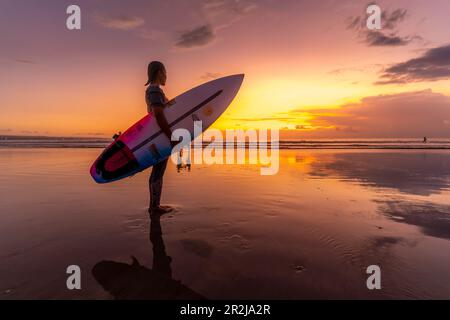 Blick auf Surfboarder am Kuta Beach bei Sonnenuntergang, Kuta, Bali, Indonesien, Südostasien, Asien Stockfoto
