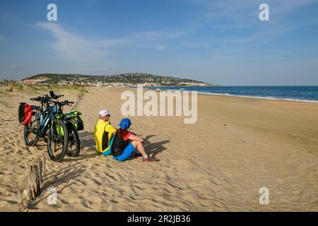 Zwei Radfahrer machen eine Pause am Strand von Sete, Sete, Canal du Midi, Canal du Midi, UNESCO-Weltkulturerbe Canal du Midi, Mittelmeer, Okzitania, Frankreich Stockfoto