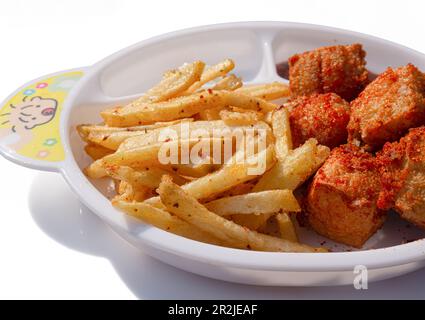 Pommes Frites auf einem weißen Teller auf weißem Hintergrund Stockfoto