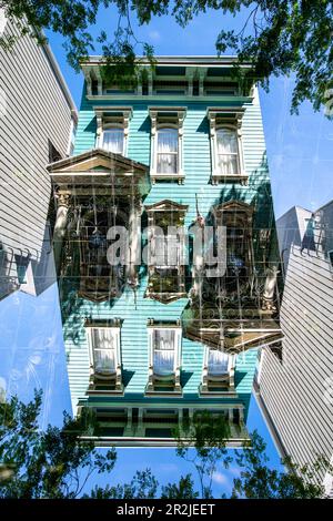 Ein farbenfrohes hölzernes Wohngebäude im viktorianischen Stil im berühmten Missionsviertel von San Francisco, Kalifornien, ist doppelt sichtbar. Stockfoto