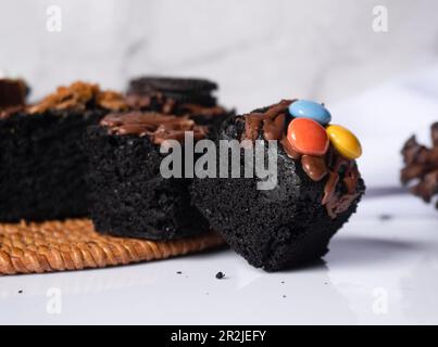 Frische Brownies auf weißem Hintergrund. Köstlicher und süßer Schokoladenkuchen Stockfoto