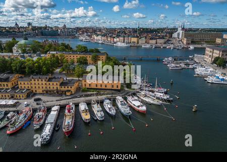 Luftaufnahme der Boote entlang der Insel Skeppsholmen mit der Stadt dahinter, Stockholm, Stockholm, Schweden, Europa Stockfoto
