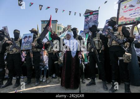 Gaza, Palästina. 19. Mai 2023. Eine palästinensische Frau steht unter den islamischen Dschihad-Kämpfern während einer Kundgebung zum Gedenken an die Kommandeure und Agenten der Gruppe, die Israel im jüngsten grenzüberschreitenden Konflikt in Gaza-Stadt getötet hat. Kredit: SOPA Images Limited/Alamy Live News Stockfoto