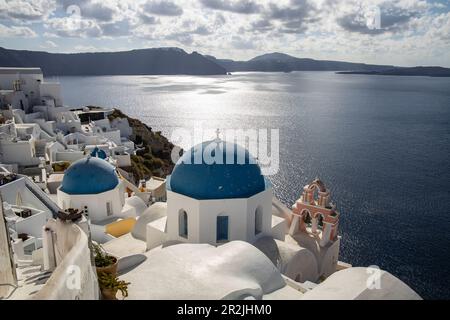 Blaue Kuppel einer griechisch-orthodoxen Kirche mit Glockenturm und Häusern auf Klippen, Oia, Santorin, Südägäis, Griechenland, Europa Stockfoto