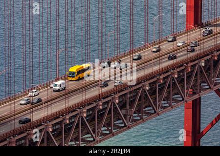 Detail der Brücke über den Fluss Tejo vom 25. April mit Autos und einem gelben Bus unter den Brücken, Lissabon, Portugal Stockfoto